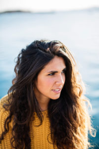 Portrait of young woman looking away while sitting on pier.Summertime